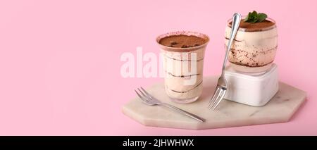 Verres avec tiramisu savoureux sur fond rose avec espace pour le texte Banque D'Images