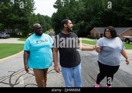 19 juillet 2022, Athènes, Géorgie, États-Unis: Les professionnels de soutien direct qui aident et prennent soin des personnes handicapées vivant dans leur propre foyer sont de plus en plus en manque, en grande partie en raison de bas salaires horaires dans la face de l'inflation. Les organisations à but non lucratif qui gèrent les soignants sont frustrées par des fonds limités provenant des budgets de dispense Medicaid de l'État, mettant des milliers de personnes dans la population nationale de personnes handicapées à risque, selon les défenseurs de l'invalidité. Photo : Josh Hall et Breanna Hill, tous deux des professionnels du soutien direct, marchent avec leur client Kason Jackson, 33 ans, qui est principalement non verbal A. Banque D'Images