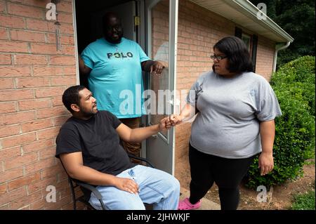 Athènes, Géorgie, États-Unis. 19th juillet 2022. Les professionnels du soutien direct qui aident et prennent soin des personnes handicapées vivant dans leur propre foyer sont de plus en plus rares, en grande partie en raison des bas salaires horaires dans la face de l'inflation. Les organisations à but non lucratif qui gèrent les soignants sont frustrées par des fonds limités provenant des budgets de dispense Medicaid de l'État, mettant des milliers de personnes dans la population nationale de personnes handicapées à risque, selon les défenseurs de l'invalidité. Photo : Josh Hall et Breanna Hill, tous deux des professionnels du soutien direct, avec leur client Kason Jackson, 33 ans, qui est principalement non verbal et e Banque D'Images