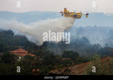Kostanjevica Na Krasu, Slovénie. 20th juillet 2022. Un avion de lutte contre les incendies de Canadair dépose de l'eau sur un grand feu de forêt près de Kostanjevica na Krasu. Plus d'un millier de pompiers, avec l'appui aérien d'un avion croate de lutte contre les incendies de Canadair, de trois hélicoptères slovènes, d'un hélicoptère autrichien et d'un avion de l'armée slovène Pilatus PC-9, ont lutté contre un grand feu de forêt qui a éclaté il y a quatre jours et s'est intensifié dans la région de Karst en Slovénie. Les habitants de cinq villages de la région ont déjà été évacués. (Photo de Luka Dakskobler/SOPA Images/Sipa USA) crédit: SIPA USA/Alay Live News Banque D'Images