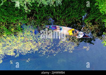 Vue aérienne des touristes qui pagayent dans un canoë lors d'une excursion d'une journée, explorant la rivière Krka et la nature sauvage de ses environs, la région de Dolenjska, Slovénie Banque D'Images
