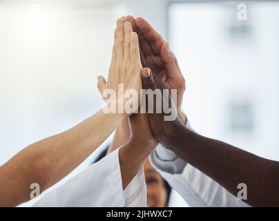 S'unir pour le bien du patient. Gros plan d'un groupe de médecins non reconnaissables se joignant à leurs mains au cours d'un caucus Banque D'Images