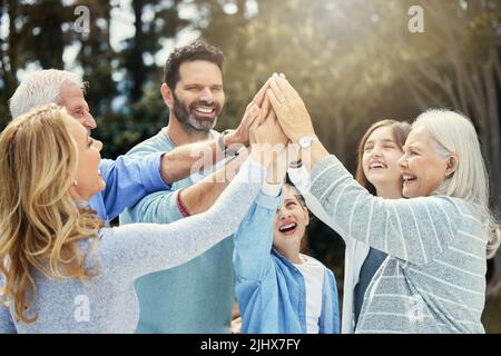 La famille vous fait qui vous êtes et qui vous arent. Une famille se donnant un cinq haut dans le jardin à la maison. Banque D'Images