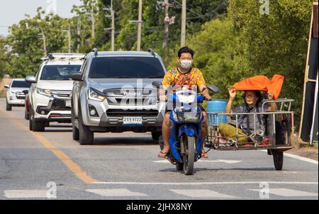 BANGKOK, THAÏLANDE, APR 29 2022, Un jeune homme est porte une vieille femme sur un chariot par une moto Banque D'Images