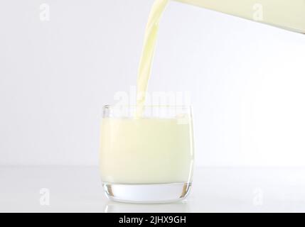 Verser le lait dans une tasse en verre Banque D'Images