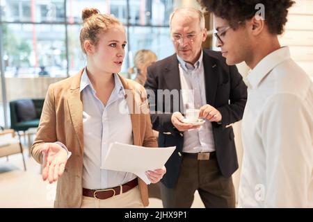 Jeune femme d'affaires discutant avec ses collègues d'un problème de planification stratégique Banque D'Images