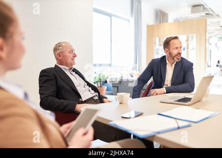Deux hommes d'affaires de l'équipe de conseil sont assis à la table de conférence dans le bureau Banque D'Images