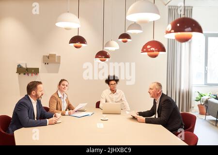 Groupe de personnes en voyage d'affaires assis à une réunion à la table dans la salle de conférence Banque D'Images