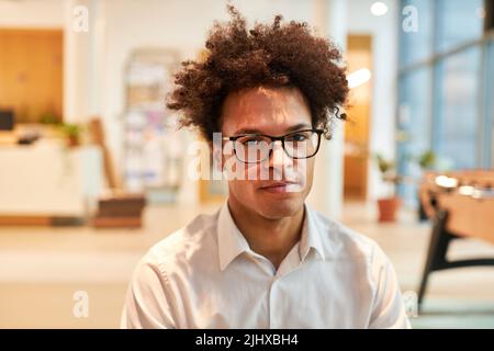 Jeune homme africain comme entrepreneur de démarrage avec la coiffure d'afro dans son bureau Banque D'Images