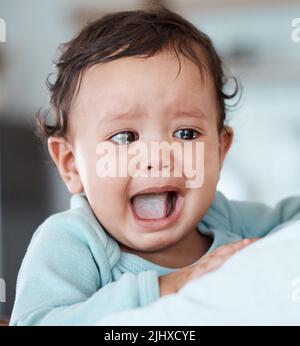 Nourrissez-moi maintenant. Un homme méconnaissable tenant son petit-enfant pleurant à la maison. Banque D'Images