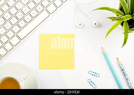 Annonces importantes sur des morceaux de papier sur le bureau avec fleur, casque, stylo, trombones, boisson chaude et clavier. Idées de base sur la note du tableau Banque D'Images