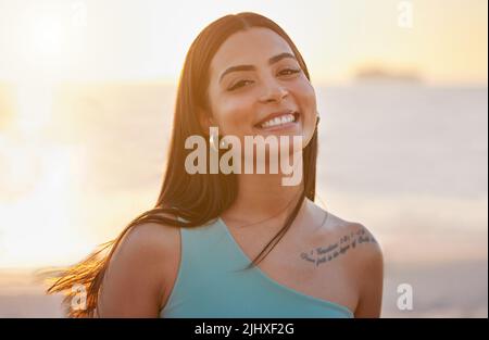 Pas du tout et c'est gratuit. Une belle jeune femme qui profite d'un peu de temps à la plage. Banque D'Images