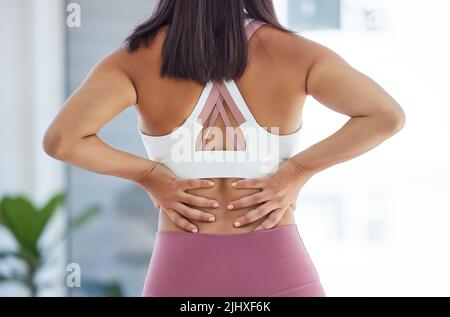 Faites attention, sinon vous casserez le dos. Vue arrière d'une jeune femme sportive qui la represse dans un studio de yoga. Banque D'Images