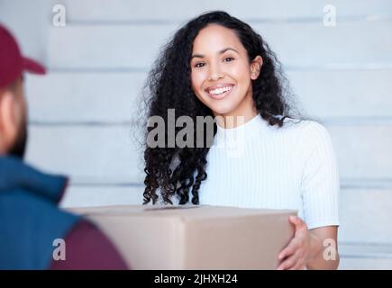 Le système IVE attendait cela. Portrait court d'une jeune femme attrayante recevant son paquet d'un liveur. Banque D'Images