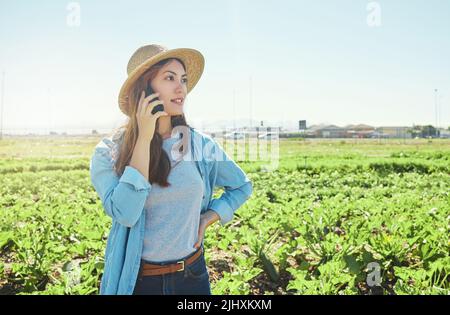Je suis prête à commencer l'expédition. Une jeune agricultrice utilise son téléphone pour faire un appel. Banque D'Images