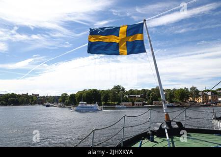 La vie quotidienne à Stockholm, en Suède, le dimanche. Un drapeau suédois sur un bateau à Djurgården. Banque D'Images