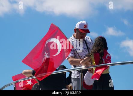 Turquie - juillet 2022 : une petite fille agitant le drapeau turc sur un navire. Jeune photographe féminine prenant la photo d'une petite fille qui agite le drapeau turc à bord. Banque D'Images