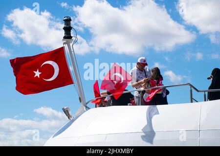 Turquie - juillet 2022 : une petite fille agitant le drapeau turc sur un navire. Jeune photographe féminine prenant la photo d'une petite fille qui agite le drapeau turc à bord. Banque D'Images