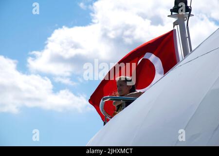 Turquie - juillet 2022 : une petite fille agitant le drapeau turc sur un navire. Jeune photographe féminine prenant la photo d'une petite fille qui agite le drapeau turc à bord. Banque D'Images