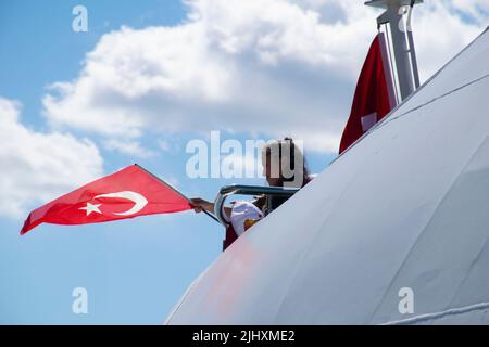 Turquie - juillet 2022 : une petite fille agitant le drapeau turc sur un navire. Jeune photographe féminine prenant la photo d'une petite fille qui agite le drapeau turc à bord. Banque D'Images