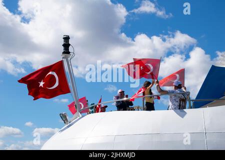 Turquie - juillet 2022 : une petite fille agitant le drapeau turc sur un navire. Jeune photographe féminine prenant la photo d'une petite fille qui agite le drapeau turc à bord. Banque D'Images