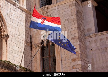 Drapeaux croates et européens de l'Union européenne venant de la construction dans la vieille ville de Dubrovnik. La Croatie est le plus jeune pays qui a rejoint l'Union européenne en Banque D'Images