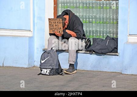 KIEV, UKRAINE - 26 MARS 2021: Jeune homme endormi, fatigué et sans emploi inconnu en costume noir demandant de l'argent pour le billet et la nourriture sur 26 mars 2021 à Kiev Banque D'Images