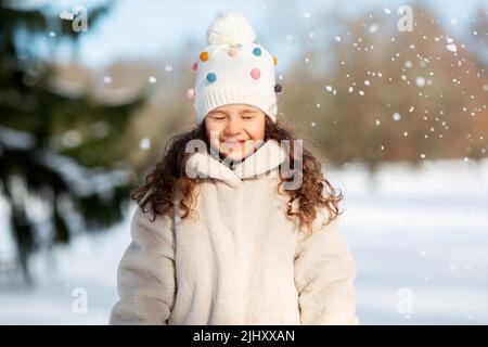 Happy little girl in winter clothes outdoors Banque D'Images