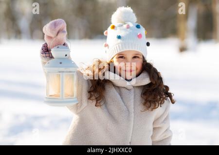 bonne petite fille avec lanterne de noël en hiver Banque D'Images