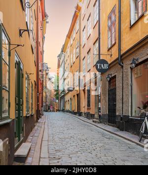 Stockholm, Suède - 26 juin 2022: Ruelle étroite située à Gamla stan, la vieille ville de Stockholm, Suède avec des maisons anciennes et colorées et une rue pavée Banque D'Images