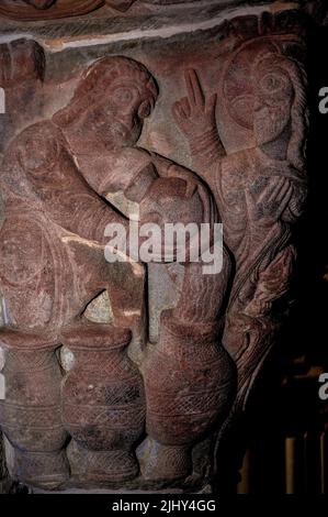 Mariage ou fête de mariage à Cana. Comme un serviteur verse de l'eau en pots, Jésus transforme l'eau en vin. Capitale romane en pierre, sculptée vers 1190 après J.-C., dans un cloître d'un monastère bénédictin, le Monasterio de San Juan de la Peña, près de Jaca dans la province de Huesca, Aragon, Espagne. L'œuvre est l'une des 20 capitales romanes de ce cloître monastère par le même sculpteur, connu comme le Maître de San Juan de la Peña ou Maître d'Aguero. Banque D'Images