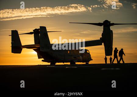 Cadix, Espagne. 15 juillet 2022. Un avion à rotor inclinable VM-22 Osprey des États-Unis, affecté à l'élément de combat d'aviation, 22nd Marine Expeditionary Unit, est silhoueté par le soleil sur le pont de vol du navire d'assaut amphibie de classe Wasp USS Kearsarge naviguant dans l'océan Atlantique, à 15 juillet 2022 près de Cadix, en Espagne. Crédit : Sgt. Armando Elizalde/États-Unis Marine corps/Alamy Live News Banque D'Images