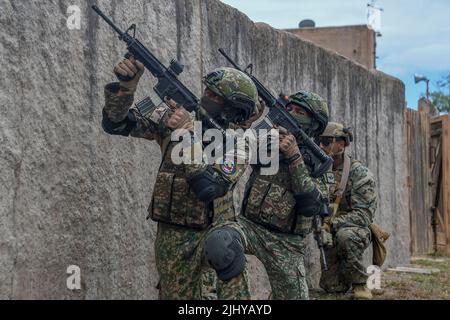 Waimanalo, États-Unis. 18 juillet 2022. Des soldats de l'armée malaisienne et une marine américaine assurent la couverture lors d'un exercice de guerre de terrain urbain simulé pendant les exercices de la ceinture du Pacifique, 18 juillet 2022 à la station aérienne de Bellows, à Hawaï. Crédit: MCS Leon Vonguyen/US Navy/Alamy Live News Banque D'Images