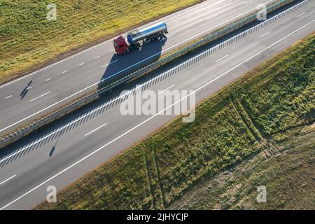 Le camion porte une citerne métallique sur une antenne d'autoroute vide au-dessus de la vue Banque D'Images