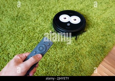 contrôle à distance des appareils électroniques dans l'appartement. concept de contrôle de l'électronique intelligente dans la maison. Internet des objets. Un homme contrôle un robot. Réno Banque D'Images