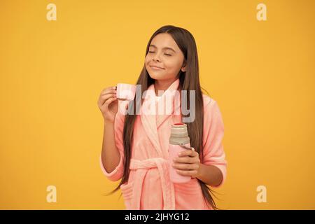 jeune fille rêveuse à la maison en éponge peignoir avec bouteille de thermos, soif Banque D'Images