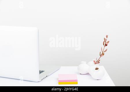 Un espace de travail bien rangé avec un ordinateur portable blanc Banque D'Images