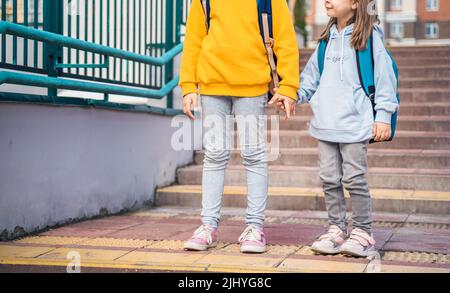 Retour à l'élémentaire, école primaire.petites filles, les sœurs avec de grands sacs à dos vont dans la hâte, de la fin à la première année seule en automne matin.Education,avenir de Banque D'Images