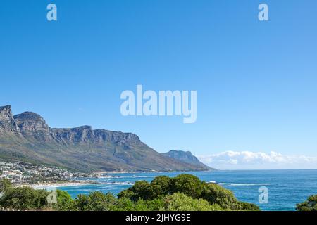 Ville côtière entourée par la nature avec un monument emblématique en arrière-plan dans la ville urbaine du Cap. Vue panoramique sur la montagne avec des plantes vertes vibrantes à proximité Banque D'Images