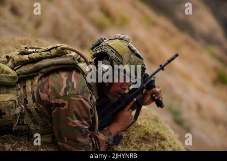 Une Marine royale de Tongan attend l'autorisation de commencer à tirer sur une cible au cours d'un exercice de simulation de guerre de terrain urbain dans le cadre des exercices de Rim of the Pacific, 12 juillet 2022, à la station de la Force aérienne de Bellows, à Hawaï. Banque D'Images