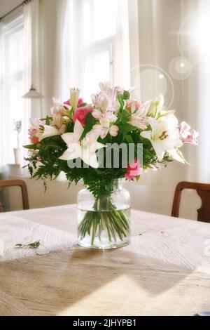 Bouquet vibrant de fleurs exposées pour la décoration intérieure. Bouquet coloré dans un vase sur une table à la maison avec une lentille de lumière. péruvien frais et pâques Banque D'Images