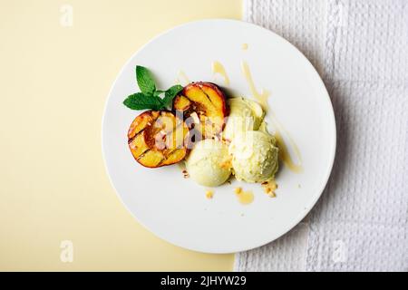 Pêches grillées et crème glacée au citron avec du miel. Banque D'Images