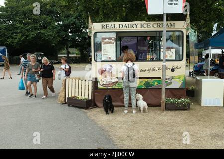 Un visiteur du spectacle avec deux chiens achète une crème glacée dans une fourgonnette à crème glacée au salon agricole de Driffield, Yorkshire, Angleterre, juillet 2022 Banque D'Images