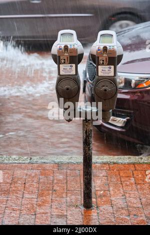 Compteur de stationnement dans une rue inondée lors de fortes pluies. Pluie d'été dans le centre-ville d'Annapolis, Maryland, États-Unis. Banque D'Images