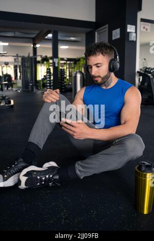Beau homme avec tatouages dans son 20s dans la salle de gym Banque D'Images