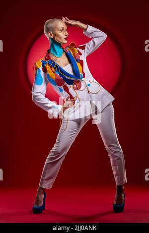 Ne les laissez pas vous mettre dans une boîte. Photo studio d'une jeune femme élégante posant sur un fond rouge. Banque D'Images