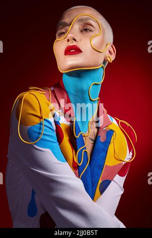 Vous avez toute la magie dont vous avez besoin dans ce monde. Photo studio d'une jeune femme élégante posant sur un fond rouge. Banque D'Images