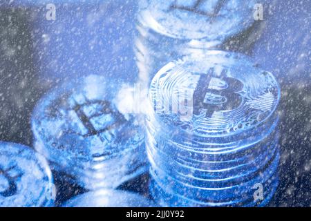 Concept pour Crypto hiver, Bitcoin dans la glace bleue. Le prix du Bitcoin s'est effondrent. Vue horizontale des jetons de crypto-monnaie, y compris Bitcoin, Ethererum Ripple et Litecoin vu d'en haut sur fond bleu de texture brillante Banque D'Images