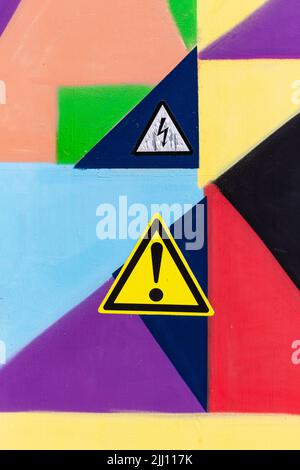 motif géométrique abstrait multicolore composé de peintures à l'huile sur la porte du tableau de commutation avec un point d'exclamation et un symbole éclair. Multicolore ab Banque D'Images