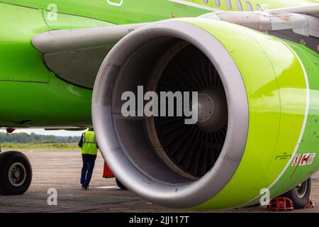 Moteur vert d'avion et personnel technique sur l'asphalte de piste. Concept de transport et de voyage. Utilisation de la technologie et des solutions d'ingénierie priorité sélective Banque D'Images